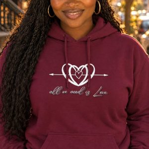 AI-generated model Nia wearing the maroon All We Need is Love hoodie on an autumn street