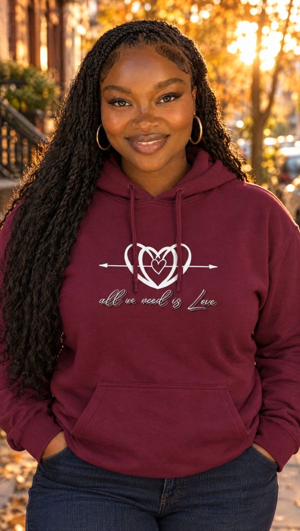 All We Need is Love hoodie – Nia (AI model) AI-generated model Nia wearing the maroon All We Need is Love hoodie on an autumn street